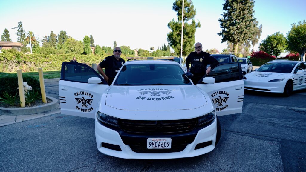 Safeguard On Demand armed security officers standing with a marked patrol car and Tesla patrol vehicle in Southern California