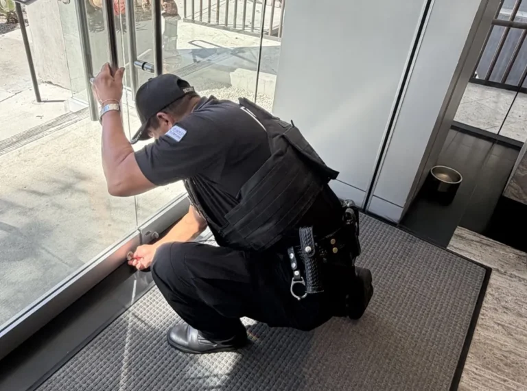 Safeguard On Demand officer performing a lock-up check on a glass storefront entrance